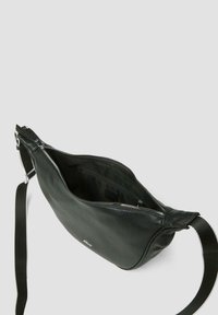 Schwarze Leder-Schultertasche mit strukturiertem Oberflächenmaterial, silbernem Reißverschluss und verstellbarem Tragegurt. Das Innere ist gefüttert und großzügig für die notwendigen Dinge.