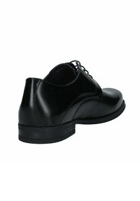 Scarpa da uomo in pelle nera con finiture lisce, punta arrotondata e design con lacci. Presenta un tacco basso impilato e dettagli di cucitura sottili.