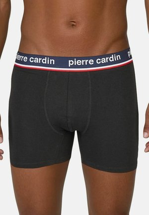 Schwarze Baumwollboxershorts mit einem marineblauen Bund, der mit weißer Schrift und roten Akzenten verziert ist. Das Design umfasst eine taillierte Silhouette und eine glatte Textur.
