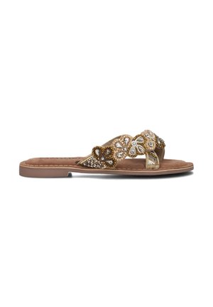 Platte sandalen met een tan kleurige binnenzool. Beaded bloemenontwerp in goud, wit en bruin op de banden. Suède-achtige textuur. Open teen stijl.