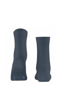 Chaussettes gris foncé avec un motif en chevrons, texture tricotée et poignets côtelés. Détail de marque distinct en bleu clair en bas.