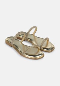 Gouden metallic sandalen met twee dunne, versierde banden en een vierkante neus. Glad oppervlak met lichte reflectie en een platte zool.