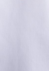 Gros plan sur un tissu bleu clair avec un motif hexagonal texturé, montrant des détails de tissage fins et des variations subtiles de couleur.