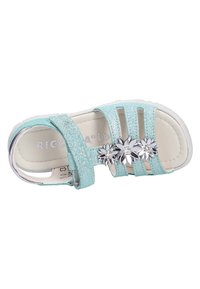 Sandalini blu chiaro glitterati con tre accenti a forma di fiore argentati, cinturino regolabile, suola piatta bianca e design aperto per una buona traspirabilità.