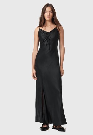 Robe maxi noire en satin avec des bretelles spaghetti, détail de fronces à l'avant et fente haute sur la cuisse. Texture lisse et silhouette ajustée.