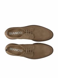 Braune Wildleder-Schnürschuhe mit glatter Textur, abgerundetem Zehenbereich und kontrastierenden Nähten. Mit einem Logo auf der Innensohle.