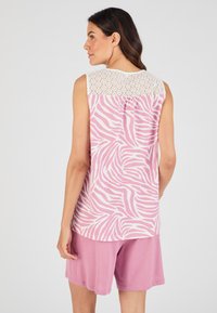 Mouwloze top met een roze zebra-print en een crèmekleurig kantpaneel aan de achterkant, gecombineerd met roze shorts. Zachte stof met een ontspannen pasvorm.