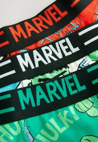 Three pairs of boxer shorts with black elastic waistbands featuring the word "MARVEL." Colors include red, black, and green with superhero patterns.