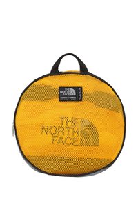 Rucsac galben din plasă, cu o formă circulară, având un fermoar și o mânere negre, și logo-ul "THE NORTH FACE" afișat proeminent.