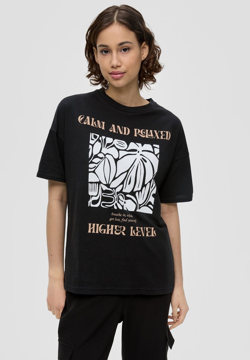 Schwarzes Baumwoll-T-Shirt mit einem weißen abstrakten Blättergrafik und Text. Kurze Ärmel, lockere Passform und runder Ausschnitt.