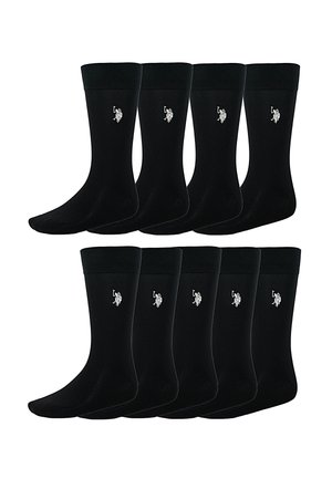 Ocho pares de calcetines negros de caña con puños acanalados, cada uno con un pequeño logo bordado en blanco de un jugador de polo en el tobillo.