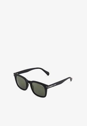 Macie czarne, prostokątne okulary przeciwsłoneczne z ciemnymi przyciemnianymi soczewkami i cienkimi zausznikami, z małymi srebrnymi akcentami oraz nazwą marki "Sinner" po boku.