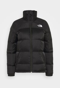 Black puffer jacket with a high collar, zip closure, and a quilted texture. Features a small white logo on the left chest.