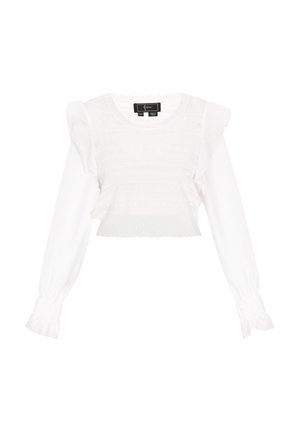 Fehér felső, textúrált kötött testtel és hosszú, fodros ujjakkal. Rugalmas mandzsettákkal és kerek nyakkivágással rendelkezik. Rövidített fazon, csipke díszítéssel.