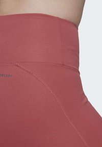 Korkeavyötäröiset, vartalonmyötäiset legginssit hillityssä ruusunsävyssä, valmistettu sileästä, joustavasta kankaasta, jossa on litteät saumat ja logotiedot.