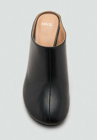Mule de cuero negro con punta redondeada y textura suave. Marca presente en la plantilla. Diseño sencillo, tacón alto, sin herrajes visibles.