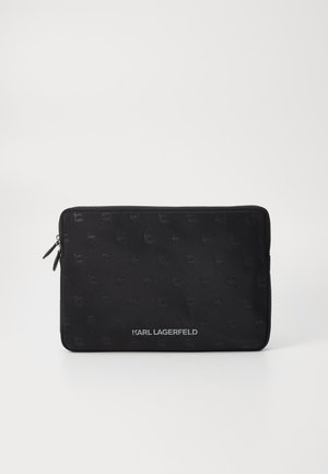 Black zippered laptop sleeve featuring a smooth texture and an embossed logo pattern, with a metal logo detail at the bottom.