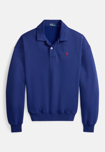 Temno modra polo majica z zloženim ovratnikom, trirazporednim zapenjanjem na gumbe in rdečim vvezenim logotipom. Izdelana iz mehke, teksturirane tkanine z rebrastimi manšetami.