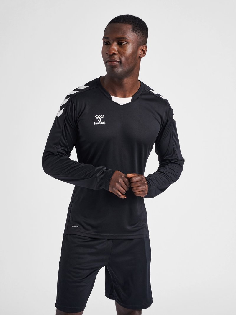 Zwarte sportshirt met lange mouwen en V-hals, voorzien van witte accenten, gecombineerd met bijpassende zwarte sportshorts. Gemaakt van een gladde, lichte stof.
