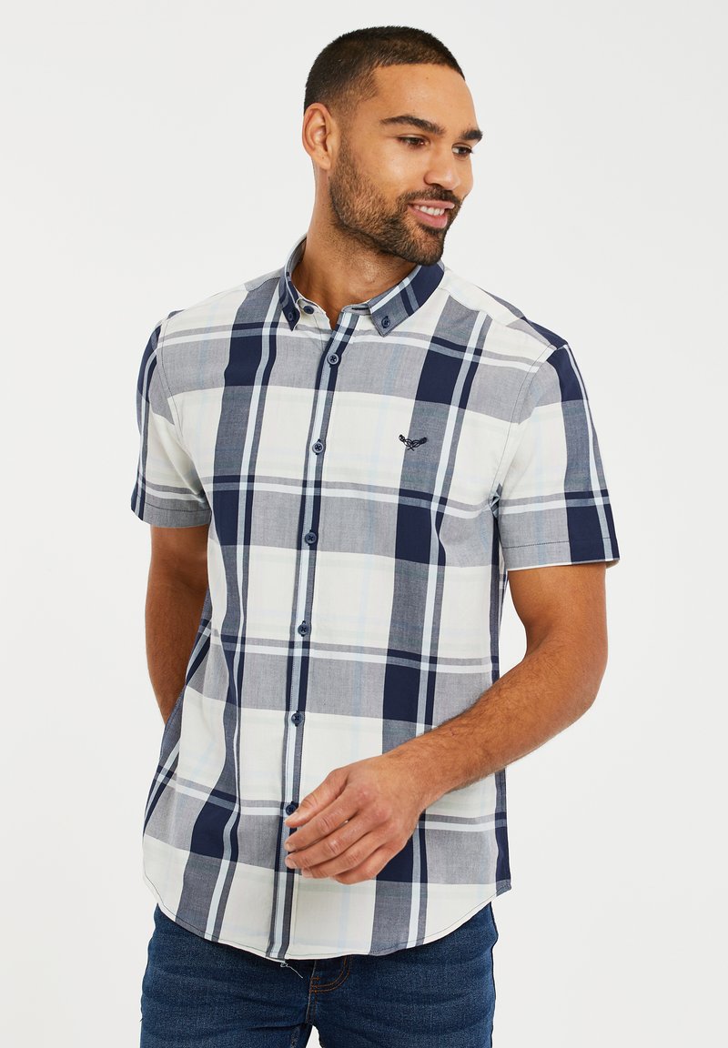Camisa de cuadros de manga corta en azul, blanco y gris con cuello abotonado y un logo en el pecho. Tejido de mezcla de algodón.