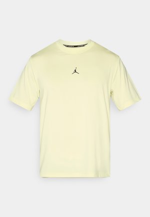 Hellgelbes T-Shirt mit kurzen Ärmeln aus glattem Stoff, mit schwarzem Jumpman-Logo in der Mitte. Rundhalsausschnitt ohne zusätzliche Verzierungen.