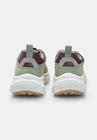 Pair of green and brown sneakers with white thick soles, viewed from the back against a plain light background.