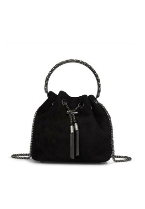 Bolso de bucket de ante negro con un mango superior redondeado y correa de cadena, con herrajes en tono plateado y borlas decorativas.