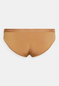 Fatos de banho castanhos da Calvin Klein com um tecido suave e elástico; apresentam uma cintura elástica suave com o logótipo da marca em relevo.