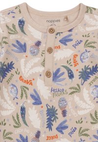 Jasno beżowa bawełniana bluzka z zapięciem na guziki, zdobiona kolorowymi wzorami owoców i liści w odcieniach niebieskiego, zielonego i czerwonego.