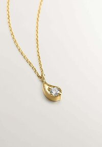 Collar de oro con colgante en forma de lágrima, adornado con una piedra preciosa clara redonda, acentuado por pequeñas cuentas de oro y un diseño retorcido.