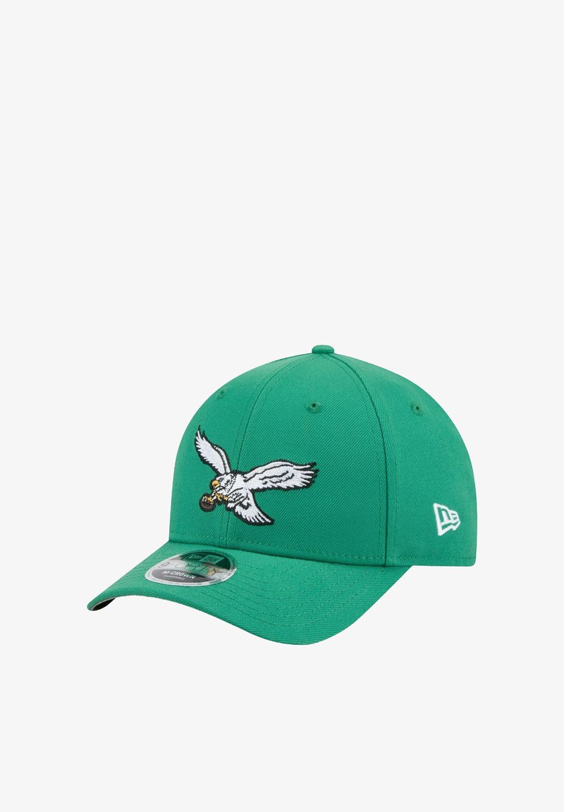 Casquette verte au design structuré, ornée d'un logo d'aigle brodé et d'un visière incurvée. Le tissu est texturé avec des accents de couture visibles.