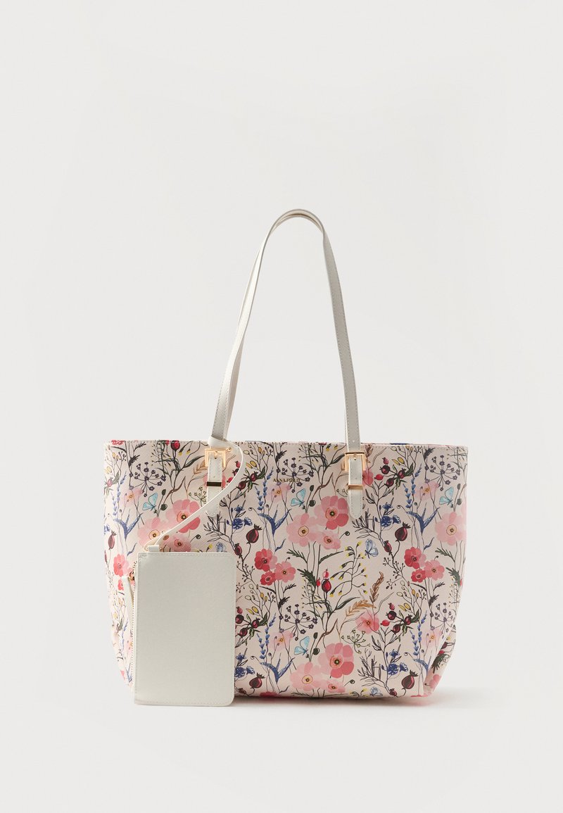 Sac fourre-tout floral avec des fleurs roses, rouges et bleues, des anses crème, et une pochette amovible assortie crème avec fermeture éclair.