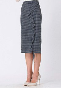 Jupe crayon bleu marine avec un motif à carreaux, dotée d'un accent volant sur le côté gauche et d'une fente, fabriquée en tissu texturé.