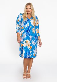 Blumenmusterkleid mit blauem Hintergrund, 3/4-Ärmeln, V-Ausschnitt und knielanger Saum. Der Stoff wirkt glatt mit leuchtend orangefarbenen und weißen Blumen.