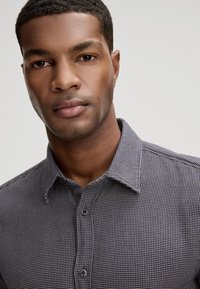 Korte mouwen overhemd in een klein ruitpatroon van marineblauw en wit, met een button-down kraag en een gladde stoftextuur.