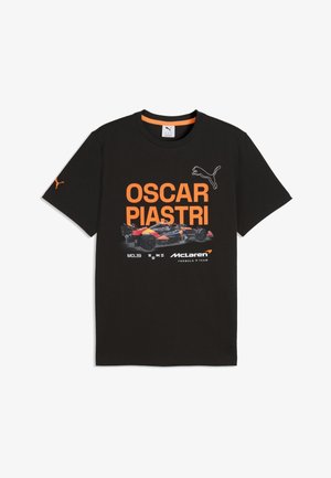Zwart Puma T-shirt met de tekst "Oscar Piastri", een afbeelding van een McLaren F1-auto, het Puma-logo en branding van het McLaren Formule 1-team in oranje en wit.