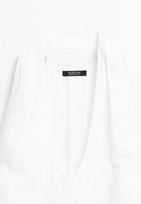 Weißes V-Neck-Top mit weicher Textur, ausgestattet mit einem Etikett, das "Massimo Dutti" trägt. Einfaches Design ohne Muster oder Akzente.