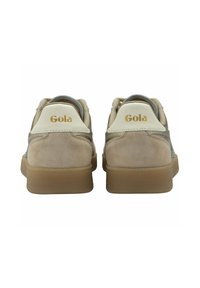 Zapatillas beige y tostadas con upper de ante y malla, logo en el talón, punta redondeada y suela de goma. Los acentos incluyen paneles texturizados.