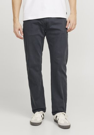 Pantalones informales azul oscuro hechos de una mezcla de algodón, diseño de pierna recta, con una cinturilla estándar y una textura sutil. Se llevan zapatillas blancas.
