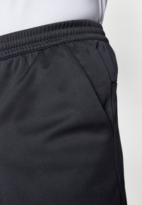 Svarta träningsshorts med elastisk midja, i en slät, strukturerad tygkvalitet och med sidofickor för funktionalitet.