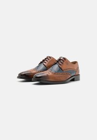 Scarpe da cerimonia in pelle marrone con una finitura lucida, caratterizzate da dettagli brogue, accenti blu e un classico design con lacci. Tacco basso.