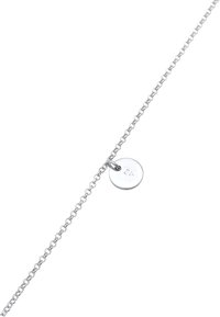 Collar de cadena de plata con un colgante redondo. El colgante presenta una superficie lisa y marcas grabadas, enfatizando un diseño minimalista.