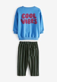 Sweat-shirt bleu avec le texte "COOL VIBES" en violet. Associé à un pantalon rayé noir et vert avec une taille élastique et une poche.