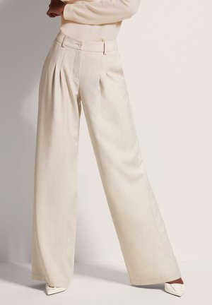 Brede broek in lichtbeige stof met een subtiele textuur, voorzien van plooien aan de voorkant, een knoopsluiting en zijzakken.