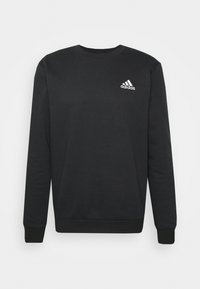 Felpa nera in cotone, con scollo rotondo, maniche lunghe, polsini a coste e un piccolo logo Adidas bianco sul petto.