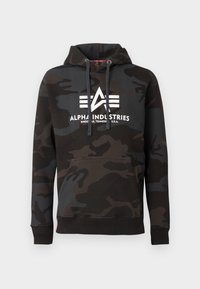 Sudadera con capucha camuflada en negro y gris oscuro, con bolsillo frontal, cordones y el logo y texto en blanco de Alpha Industries en el pecho.
