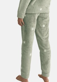 Ensemble de pyjama vert texturé avec un motif tissé et des accents d'étoiles blanches, présentant une coupe décontractée et des manches longues.