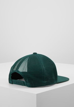 Casquette trucker en mesh vert foncé avec sangle snapback réglable posée sur une surface blanche devant un fond gris clair uni.