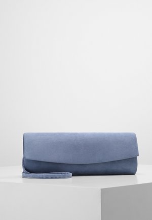 Miękka niebieska kopertówka zamszowa z zapięciem na klapę, spoczywająca na białej powierzchni na tle jednolitego szarego tła.