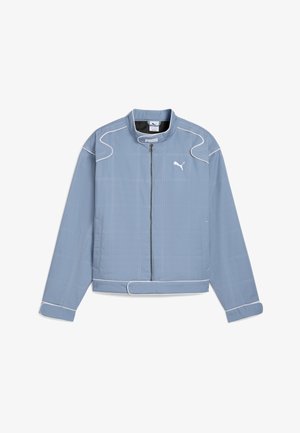 Helle blaue Jacke mit Reißverschluss vorne, runder Kragen und weißen Nähten. Sie verfügt über ein Gittermuster und zwei Seitentaschen. Mit elastischen Bündchen.